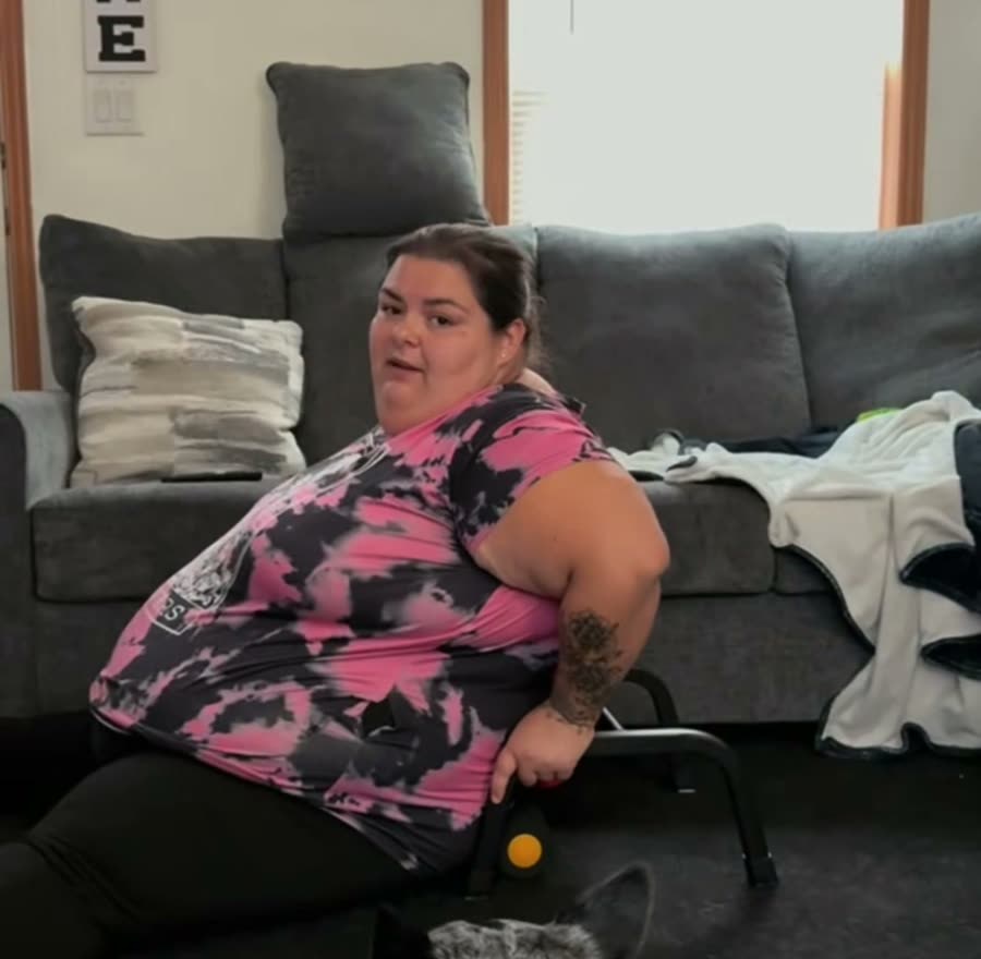 A plus-size woman on the floor with her Elva and her dog beside her